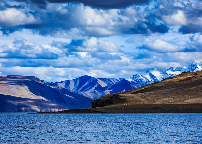 Scenic Ladakh valley surrounded by high mountains and river, green oasis amid cold desert landscape